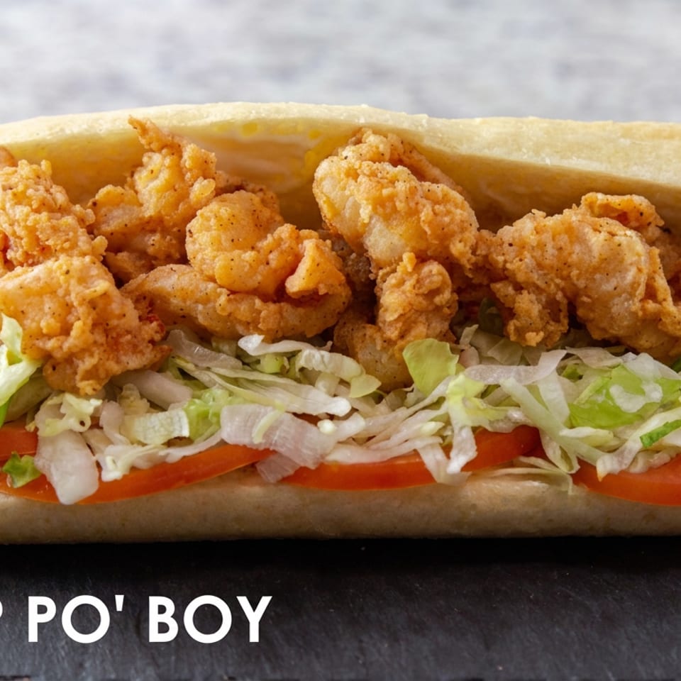 Fried shrimp po’ boy with shredded lettuce and tomato on a toasted roll.