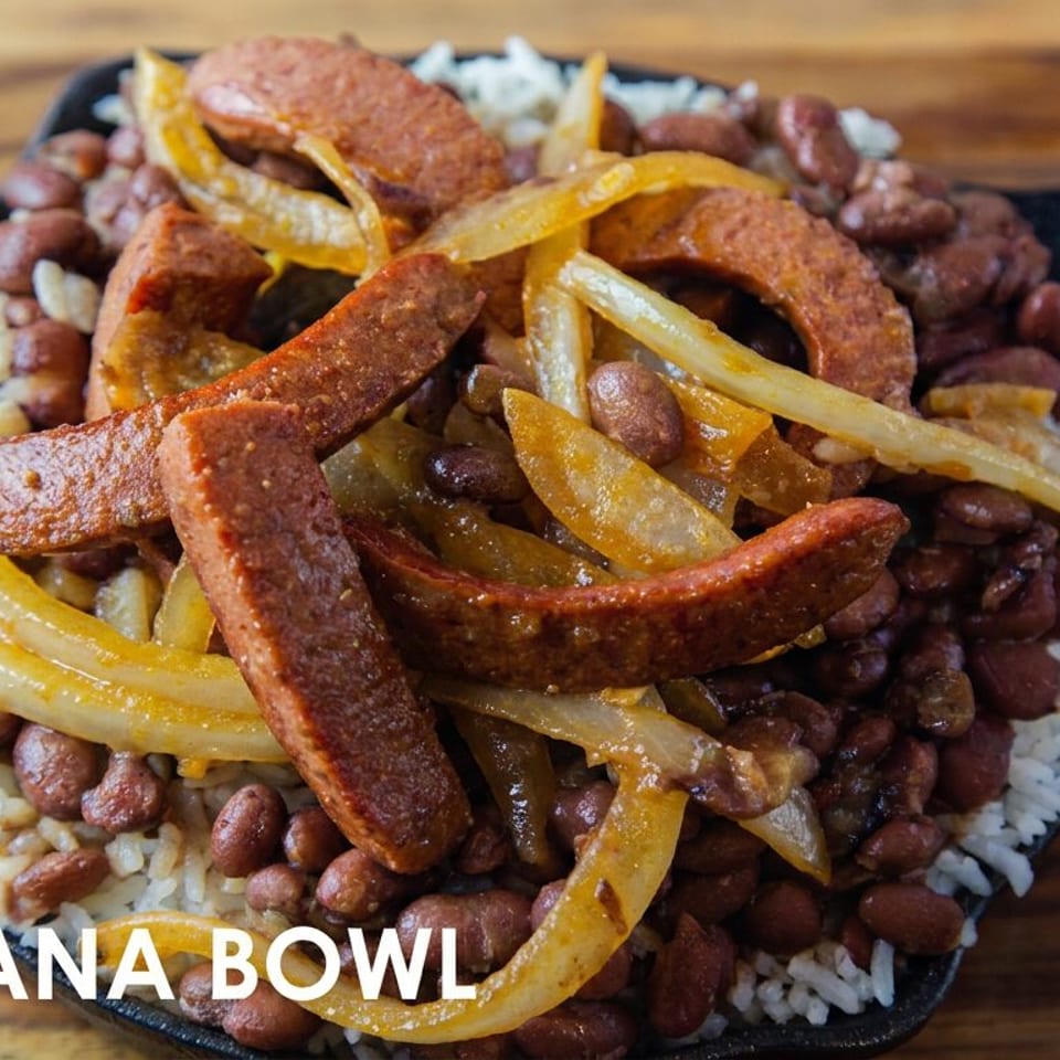 Louisiana bowl with white rice, red beans, sautéed onions, and sliced smoked sausage in a black skillet.